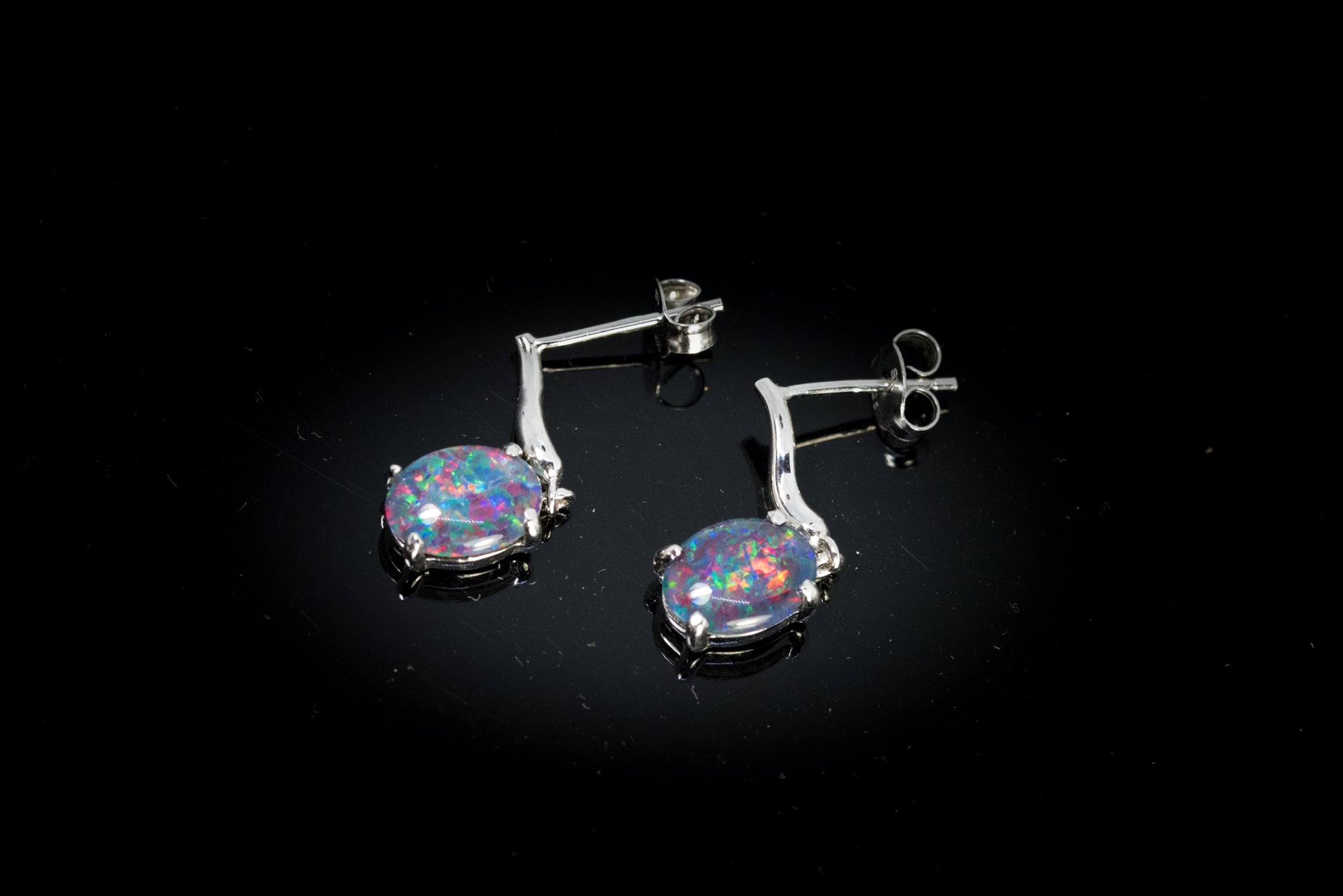 Opal earrings on a black background