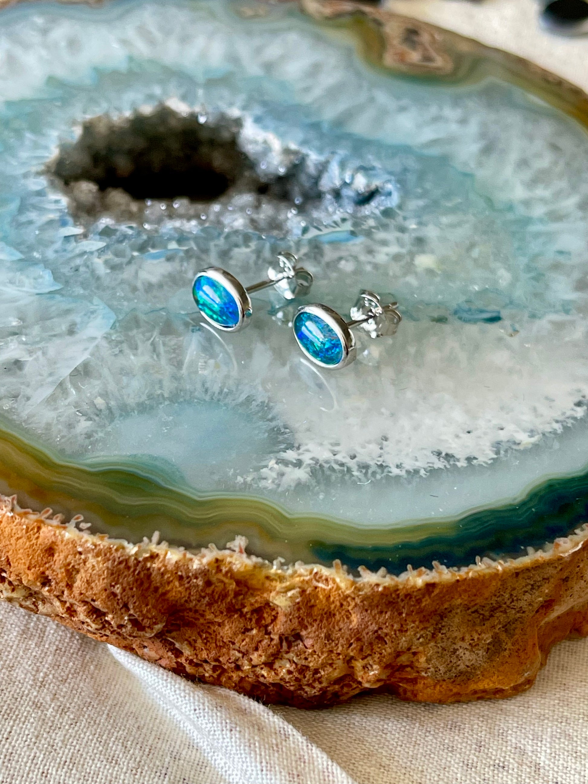 Opal stud earrings on a geode slice
