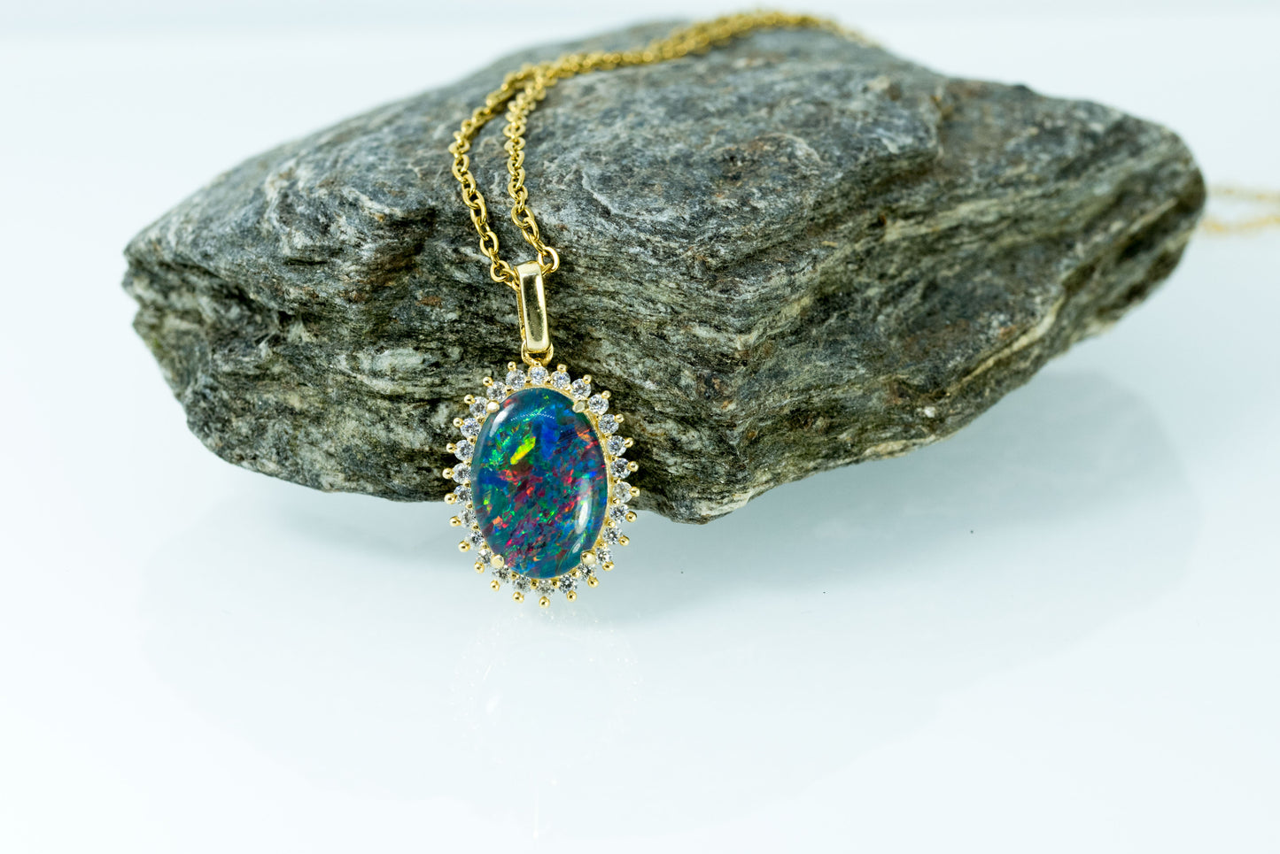 Opal necklace on a rock with a white background