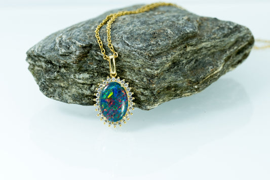 Opal necklace on a rock with a white background