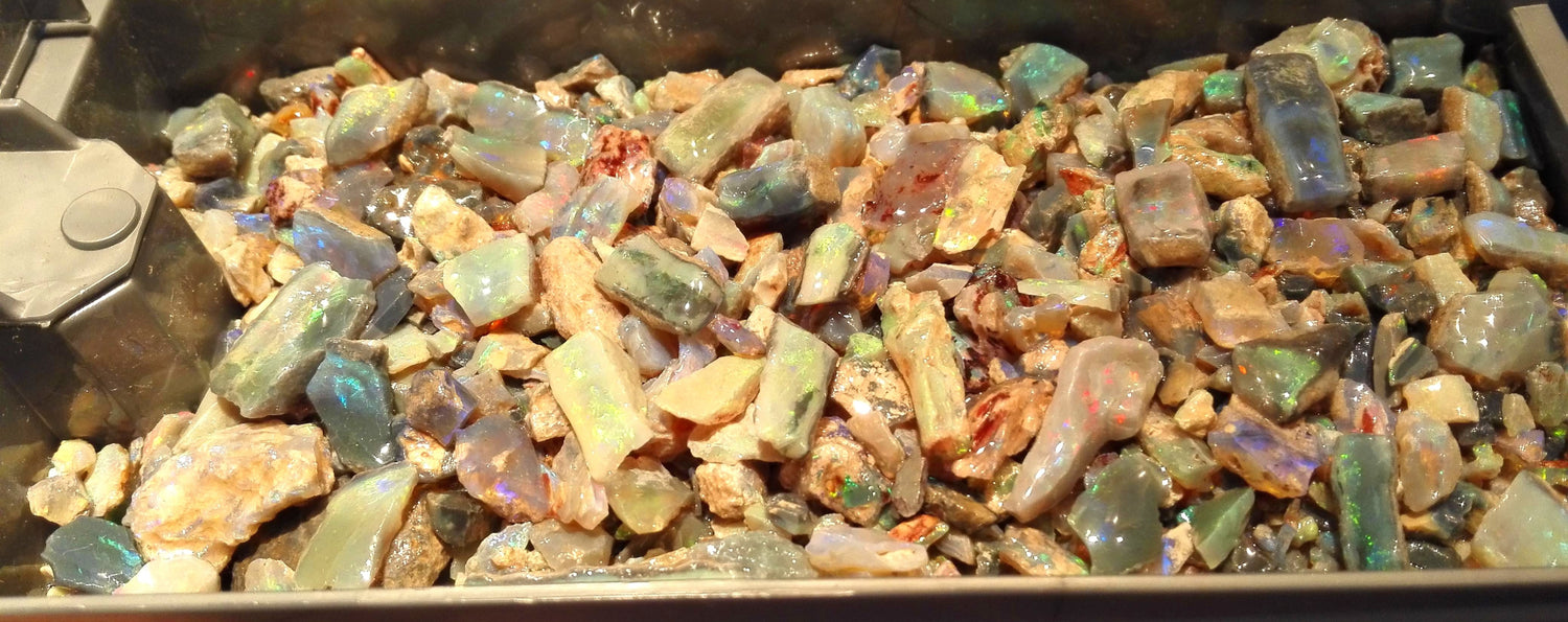 Assorted colored Australian opal stones on a dark surface