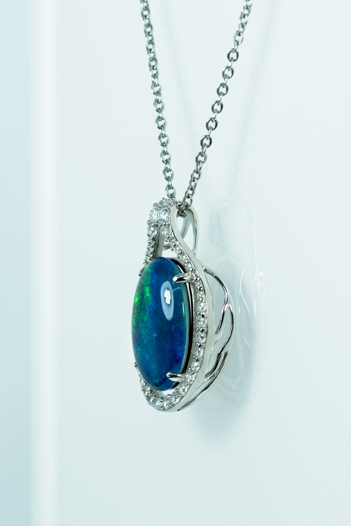 Opal pendant with diamond accents on a white background