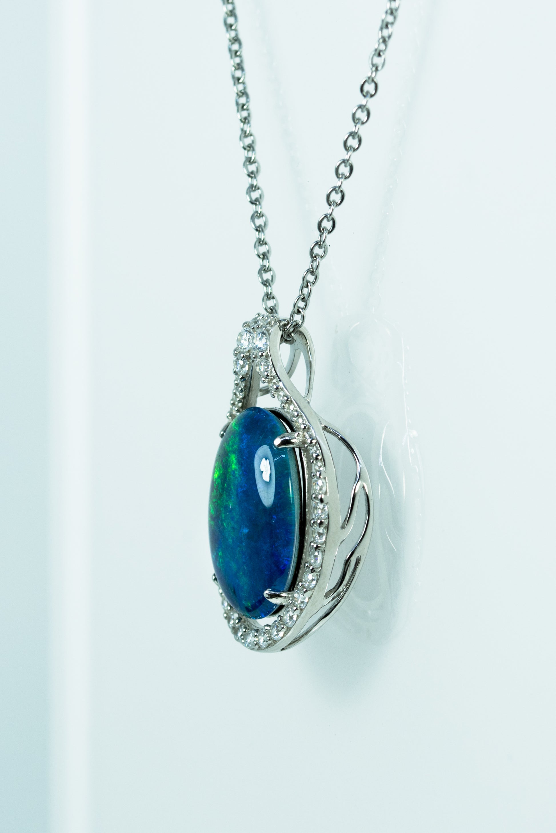 Opal pendant with diamond accents on a white background