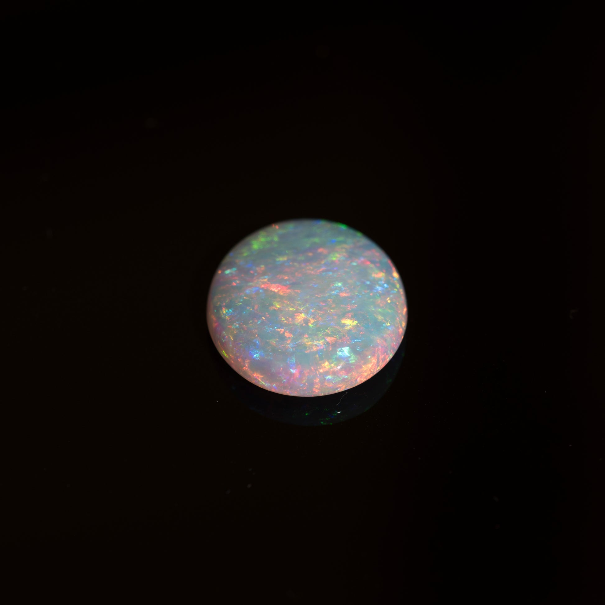 Opal gemstone with multicolor play on a black background