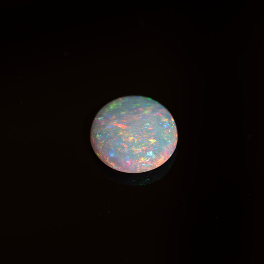 Opal gemstone with multicolor play on a black background