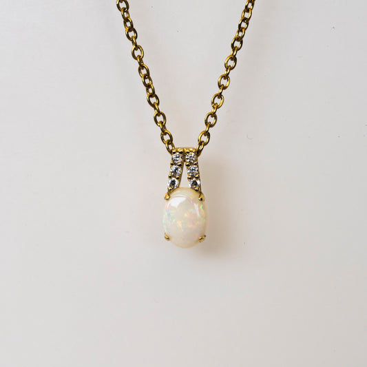 opal necklace with gold chain on a light gray background