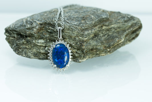 Blue Opal pendant necklace on a rock with a white background