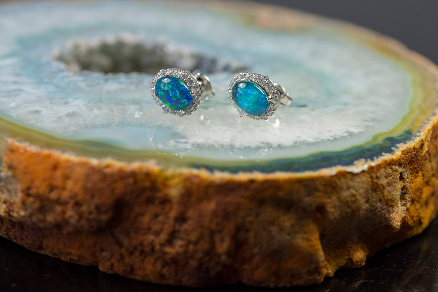 Opal earrings on a wooden surface