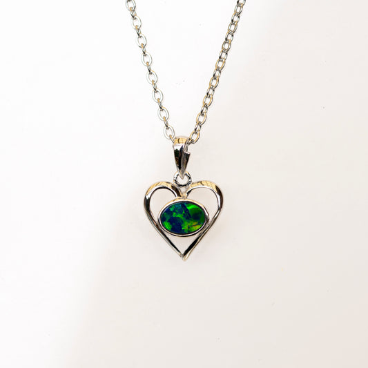 Heart-shaped pendant with green opal gemstone on a white background