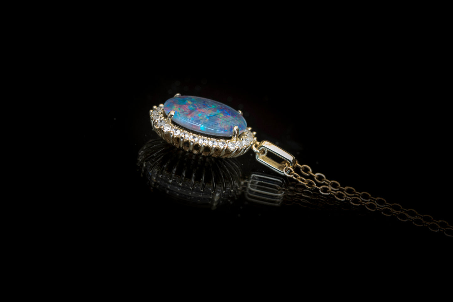 Opal pendant with chain on a black background