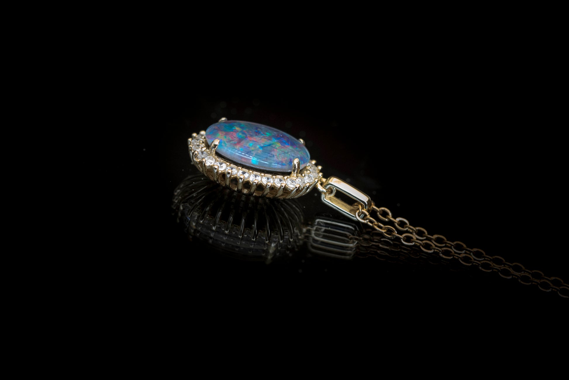 Opal pendant with chain on a black background