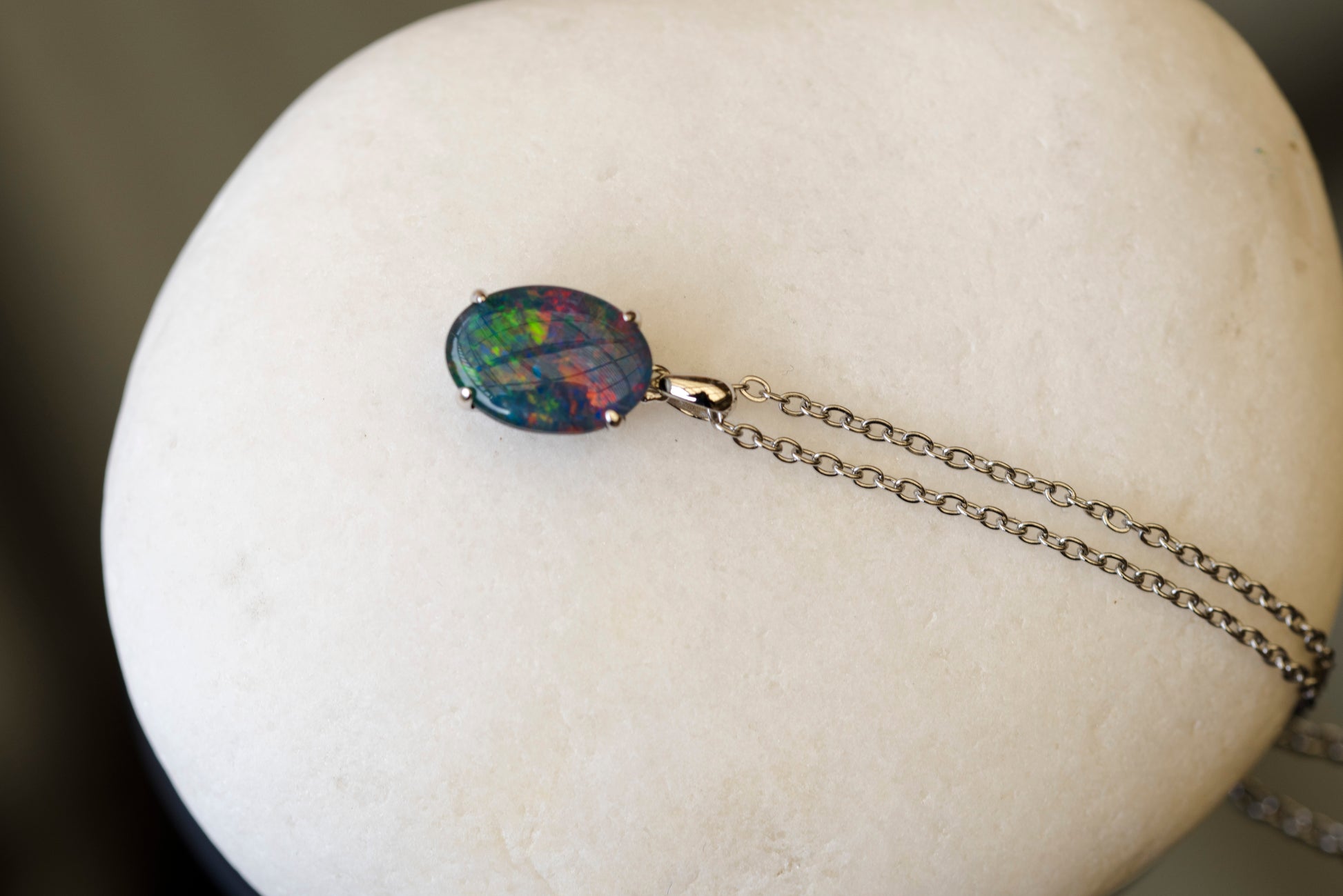 Opal pendant necklace on a white stand