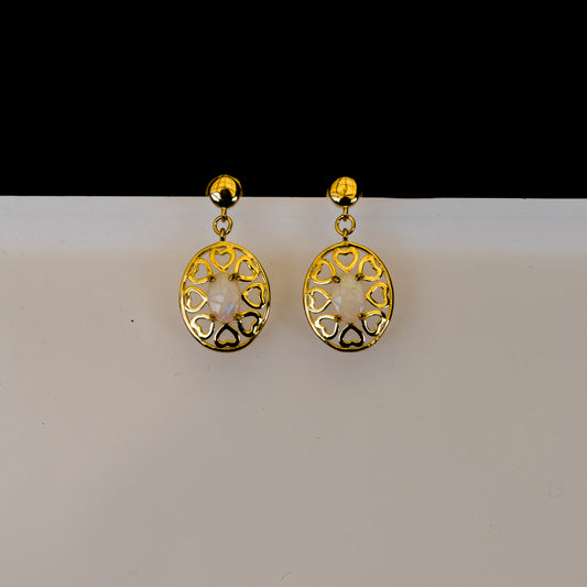 Gold earrings with intricate designs on a white background